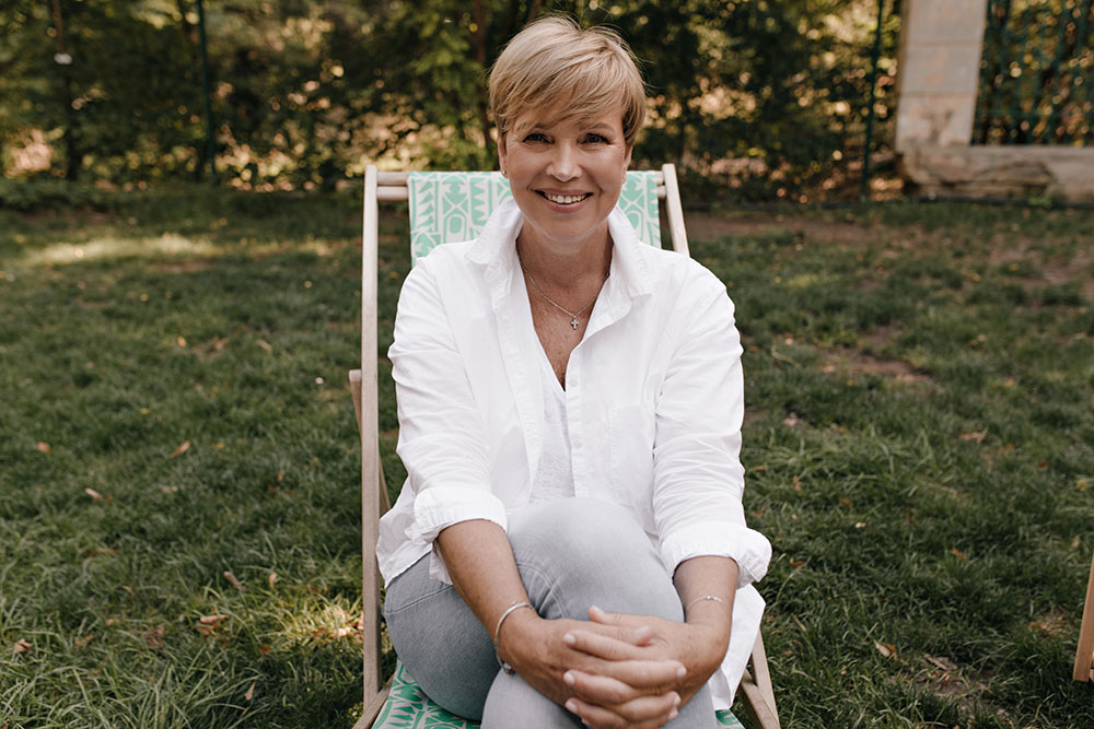 Woman Smiling sitting on chair in garden area